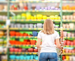 Woman with trolley in retail supermarket.