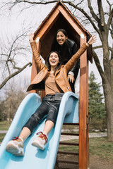 Young girls enjoying slide in the park