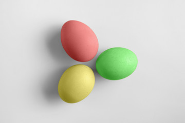 Top view of three bright painted easter eggs on white background. Colorful easter eggs decoration. Flat lay, top view. with copy space for text.