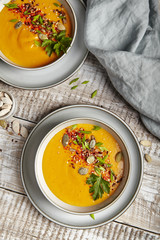 Pumpkin puree soup with seeds and greens