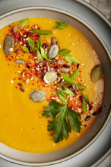 Pumpkin puree soup with seeds and greens