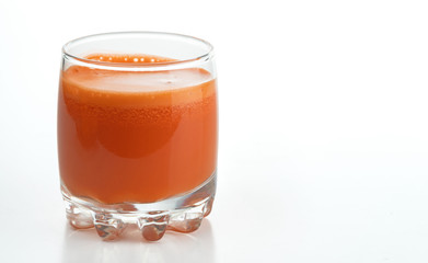 Freshly squeezed carrot juice in a glass. Isolated on a white background..