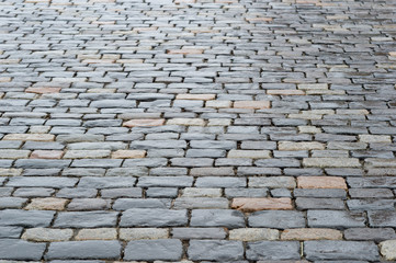 Ancient paving stones made of rectangular stone bricks. Textured background