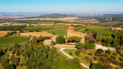 Fototapeta na wymiar Magnificent authentic Italian villa under the sun. The house is surrounded by green meadows. Aerial view with a drone in Tuscany, Italy