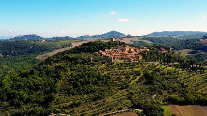 Fototapeta na wymiar Italian village of Monticchiello in Tuscany, Italy. Drone flying over the magnificent village and green meadows. Perfect for authentic travelling in Italy 