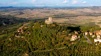 Obraz premium Aerial view with a drone over a magnificent authentic Italian village and green meadows. Beautiful old village of rocca d'orcia Tuscany, Italy. Perfect for travel and vacations