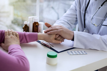 Male doctor hands holding woman hand