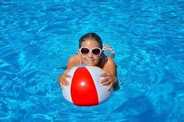 Real adorable girl relaxing in swimming pool