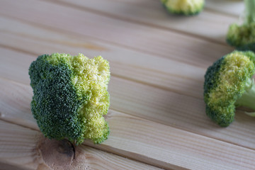 green healthy broccoli on light wood