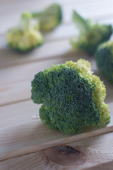 green healthy broccoli on light wood
