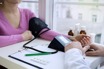 Male doctor measures the pressure with the device to the patient