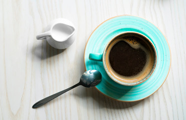 cup of coffee for milk and a spoon on the table