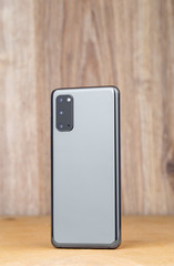 Smartphone on a wooden surface. A popular smartphone close-up.