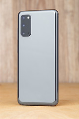 Smartphone on a wooden surface. A popular smartphone close-up.