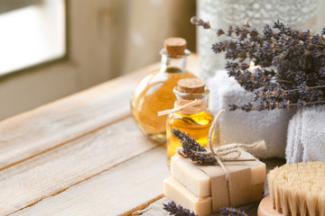 Concept of natural organic oil in cosmetology. Moisturizing skin care and aromatherapy. Gentle body treatment. Atmosphere of harmony relax. Wooden background, lavender flower, brush, soap. Copy space - obrazy, fototapety, plakaty