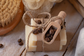 Concept of home natural organic skin care. Handmade soap bars with coffee used as gentle scrub. Brush to increase anti-cellulite effect. Relax pleasant treatement. Wooden background close up
