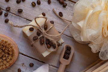 Concept of home natural organic skin care. Handmade soap bars with coffee used as gentle scrub. Brush to increase anti-cellulite effect. Relax pleasant treatement. Wooden background flat lay top view