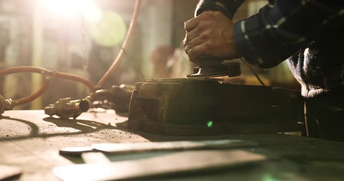 Bladesmith deburring metal with angle grinder