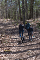 A grandmother, daughter, son and dog hiking while practicing social distancing