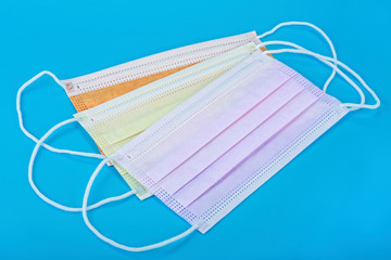 Colorful medical masks isolated on blue background. Surgical mask with rubber ear straps. Protection concept.