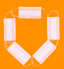 Frame made with many medical masks on an orange background, concept of protection against flu,...