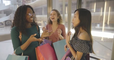 Young three women riding elevator in shopping center