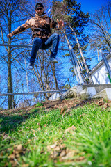 Jumping squats in nature. Man working. Man jumping in the park.