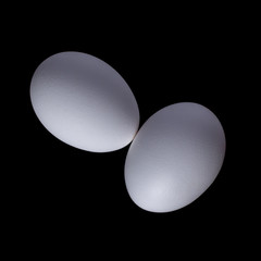 White organic chicken eggs isolated on a black background