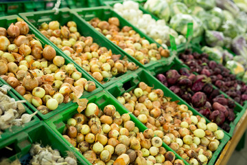 Onions and garlic on the supermarket shelf vegetable