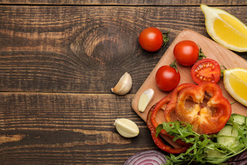 Set of sliced vegetables for making salads or other dishes on a brown wooden table. top view. place for text. ingredients for cooking.