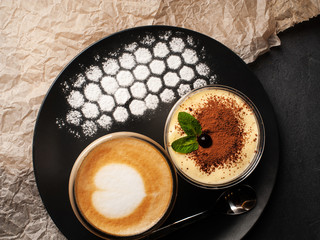 yummy tiramisu dessert with coffee on dark table. top view