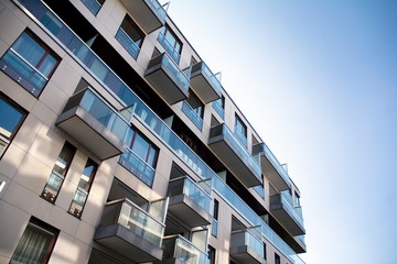 Exterior of new apartment buildings on a blue cloudy sky background. No people. Real estate...