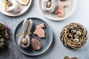 Table setting for the holiday of Easter. The photo shows white dishes, serving mat, Easter egg in a...