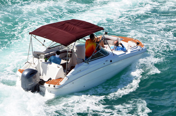Two couples enjoying an outing on the Florida Intra-Coastal Waterway in a sporty runabout motor boat.