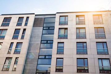Modern apartment building exterior concept. Sunshine sun flare.