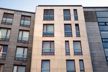 Obraz premium Exterior of new apartment buildings on a blue cloudy sky background. No people. Real estate business concept.