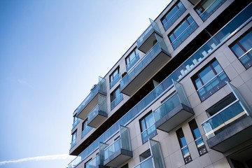 Exterior of new apartment buildings on a blue cloudy sky background. No people. Real estate business concept.