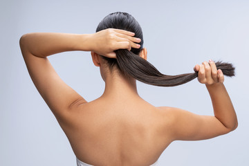 Young woman is holding her long hair