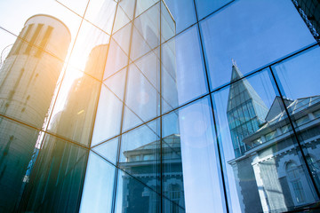 Office building glass facades on a bright sunny day with sunbeams in the blue sky. 