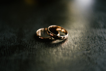 Obraz na płótnie Canvas Elegant wedding rings for the bride and groom on a black background with highlights, macro, selective focus