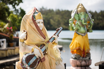 MAURITIUS, SOUTH AFRICA - OCTOBER 16, 2017 : Indian statues on the background of the lake in...