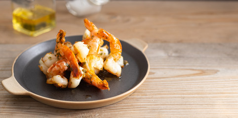Prawns with garlic on a dark plate.
