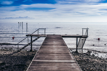 Bootssteg am Bodensee mit Blick auf die Alpen