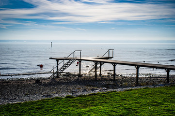 Bootssteg am Bodensee mit Blick auf die Alpen