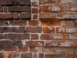 Old red grunge brick wall looks like texture. Close-up view of the brickwork with different shape bricks.