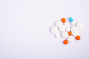 Pills and tablets on bright white background, healthcare medical concept, antibiotics and cure, top view copy space