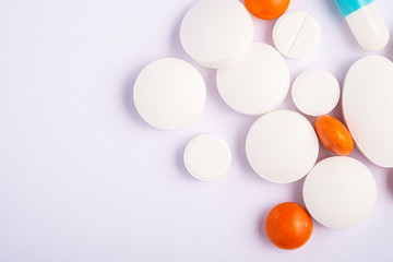 Pills and tablets on bright white background, healthcare medical concept, antibiotics and cure, top view copy space