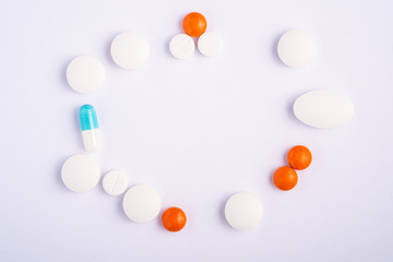 Pills and tablets on bright white background, healthcare medical concept, antibiotics and cure, top view copy space