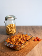 Front view of a crystal tray with grated tagliatelle over a bamboo mat and a wooden table