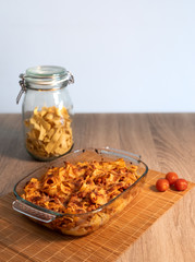 Front view of a crystal tray with grated tagliatelle over a bamboo mat and a wooden table